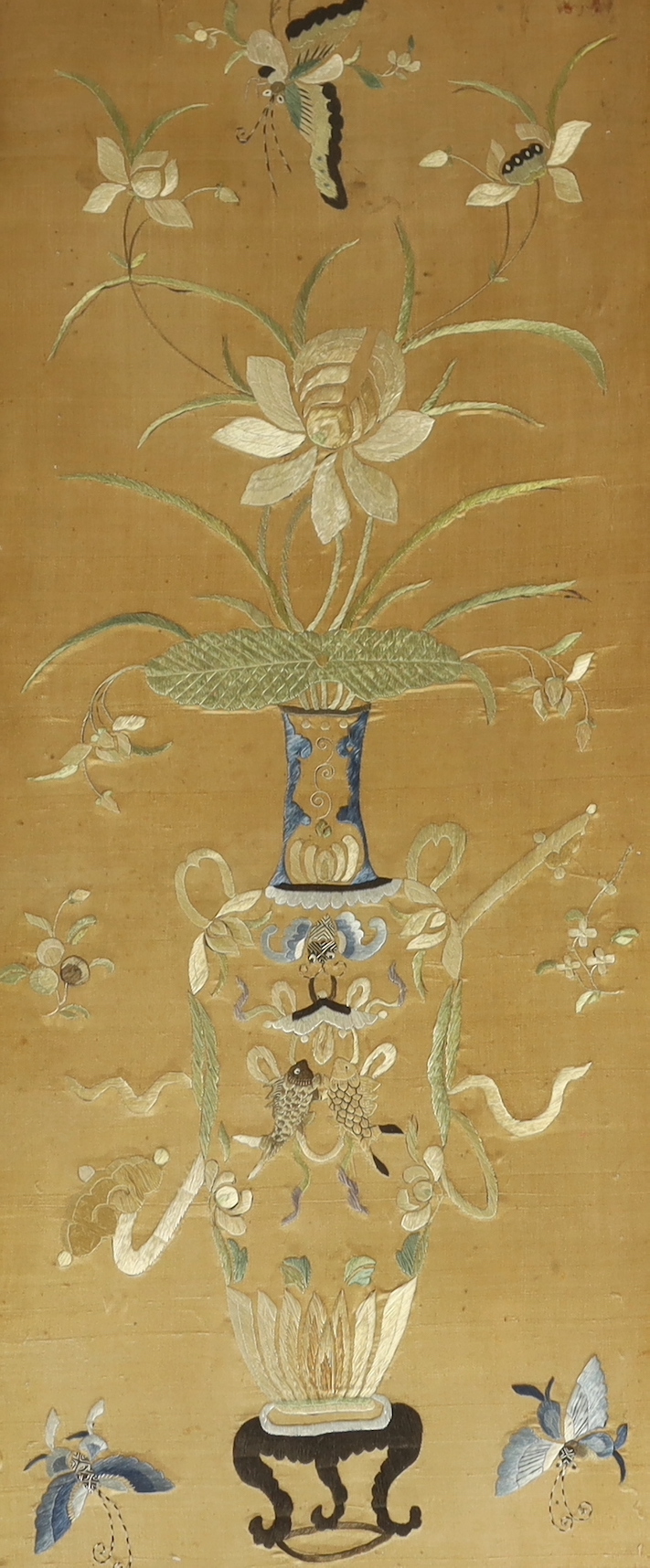 A framed 19th century Chinese silk embroidery of a vase of flowers and auspicious symbols, butterflies and fish, 36cm wide x 83cm high